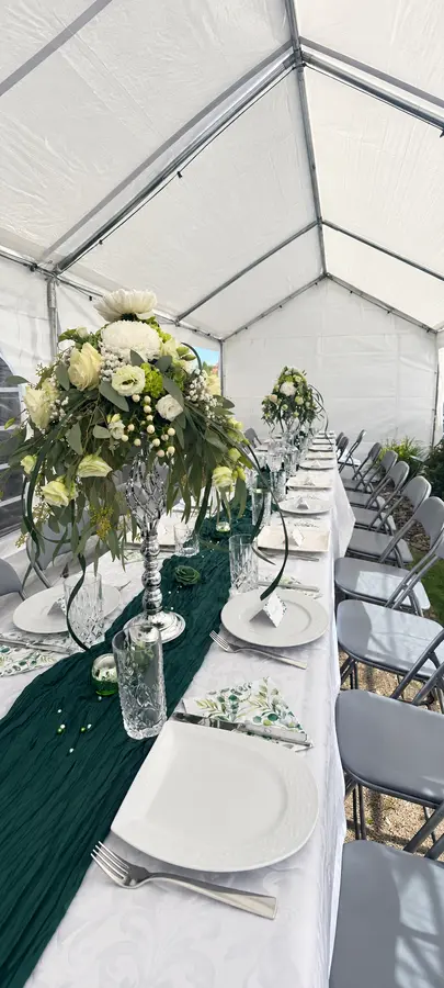 Hochzeitstafel mit Blumengestecken in Weiß und Grün