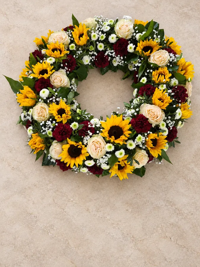Trauerkranz mit Sonnenblumen und gelben Rosen